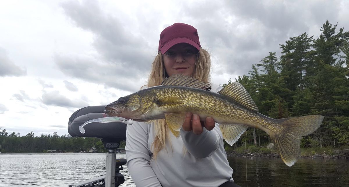 The fisherman holds the trout with a special fishing grip in the